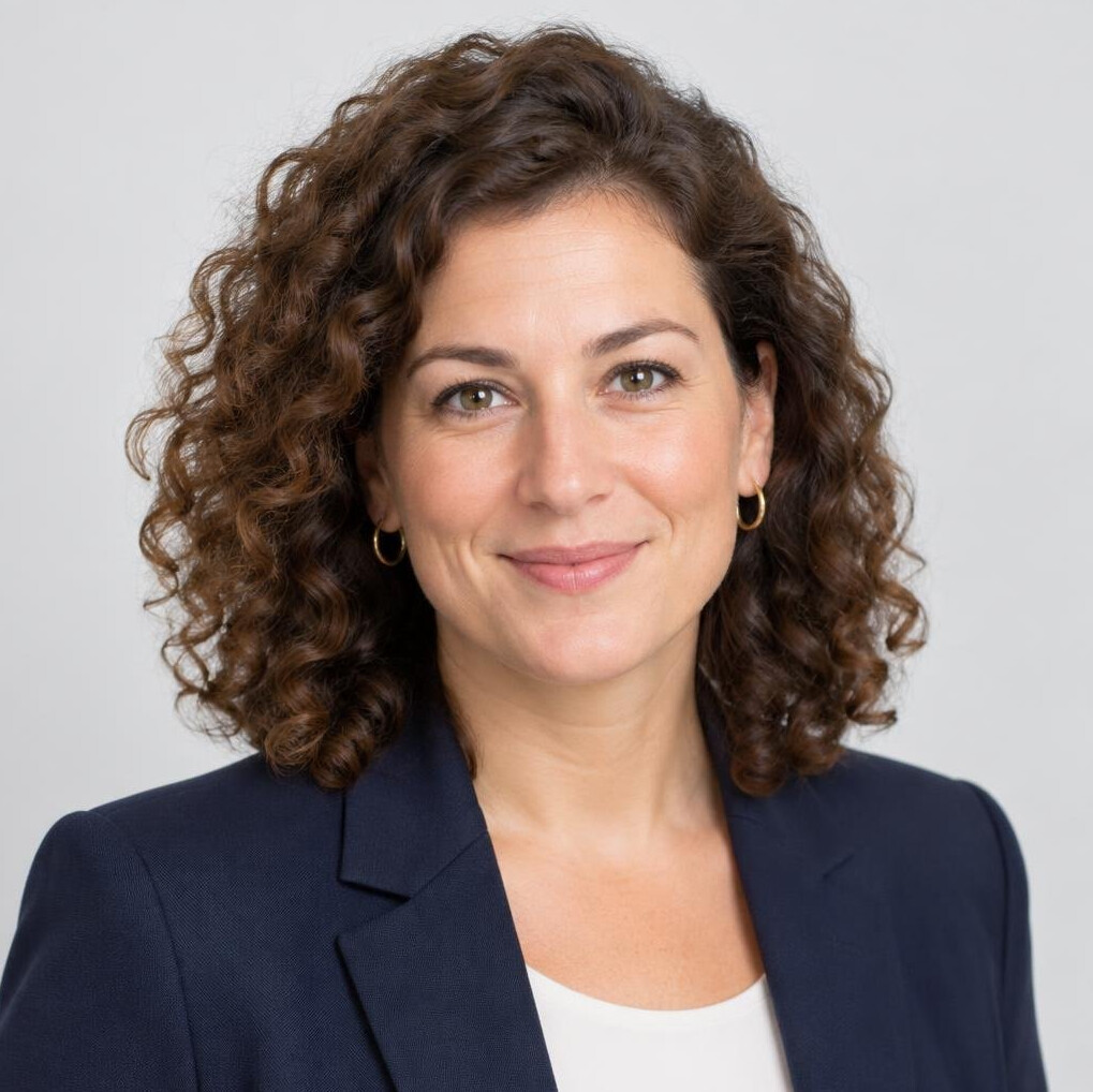 Studio headshot of a European woman with curly hair