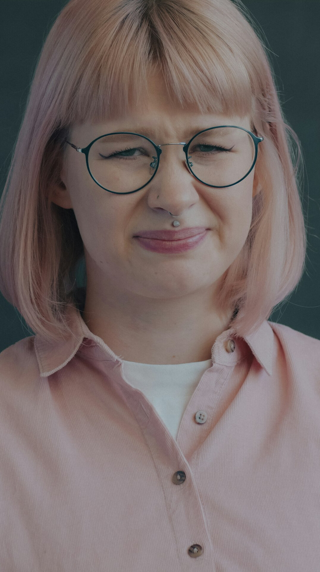 Studio headshot of an older European woman with grey hair and glasses